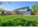 Expansive backyard with lush green grass, a wooden fence, and a raised deck with stairs leading down at 430 Chestnut Way, Broomfield, CO 80020