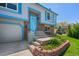 Close up of the home's front exterior with brick accents, blue trim and beautiful landscaping at 430 Chestnut Way, Broomfield, CO 80020