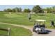 Golfer teeing off on a sunny day on the golf course with golf cart, visible distance markers, and green grass at 430 Chestnut Way, Broomfield, CO 80020
