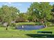 Scenic view of the golf course with a serene pond, green bench, and a golfer in the background at 430 Chestnut Way, Broomfield, CO 80020