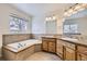 Bathroom with double sinks, soaking tub, and wood cabinets at 646 N 13Th Ave, Brighton, CO 80601