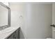 Bathroom featuring a modern vanity with storage and a decorative mirror, accented by neutral wall color and fixtures at 1259 W 112Th Ave # B, Denver, CO 80234