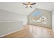 Bedroom featuring vaulted ceilings, large arched window with a view, and hardwood floors for a serene retreat at 1259 W 112Th Ave # B, Denver, CO 80234