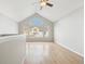 Bedroom featuring vaulted ceilings, large arched window with a view, and hardwood floors for a serene retreat at 1259 W 112Th Ave # B, Denver, CO 80234