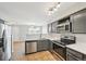 Open-concept kitchen boasts stainless steel appliances, sleek countertops, and views into the living area, ideal for entertaining at 1259 W 112Th Ave # B, Denver, CO 80234
