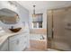 Elegant bathroom featuring a unique glass vessel sink, bathtub, and shower with gold-toned hardware at 7400 W Grant Ranch Blvd # 5, Littleton, CO 80123