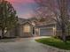 Charming home featuring a stone facade, inviting entrance, manicured lawn and a two-car garage with ample driveway parking at 7400 W Grant Ranch Blvd # 5, Littleton, CO 80123