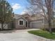 Charming home featuring a stone facade, inviting entrance, manicured lawn and a two-car garage with ample driveway parking at 7400 W Grant Ranch Blvd # 5, Littleton, CO 80123