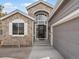 Close-up of a home with stone accents, arched window above front door, and two car garage at 7400 W Grant Ranch Blvd # 5, Littleton, CO 80123