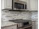 This modern kitchen features stainless steel appliances, including a microwave and electric cooktop at 7400 W Grant Ranch Blvd # 5, Littleton, CO 80123