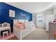 Bright bedroom with blue accent wall and white furniture at 4705 Andes St, Denver, CO 80249