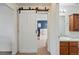 Hallway view featuring a white sliding barn door and bathroom at 4705 Andes St, Denver, CO 80249
