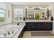 Bright bathroom featuring a soaking tub, large mirror, and natural light from a window at 10832 Montvale Cir, Highlands Ranch, CO 80130