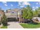Stunning two-story stucco home with stone accents, balcony, manicured lawn, and mature trees at 10832 Montvale Cir, Highlands Ranch, CO 80130