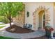 Charming stone archway leading to home's entrance with bench and potted flowers at 10832 Montvale Cir, Highlands Ranch, CO 80130
