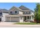 Charming two-story home with a three car garage and landscaped front yard on a sunny day at 1382 Raindrop Way, Castle Rock, CO 80109