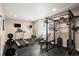 Home gym featuring treadmill, elliptical, weight rack, and TV at 1382 Raindrop Way, Castle Rock, CO 80109