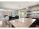Open kitchen with granite countertops, dark cabinets, and access to the living room and backyard at 1382 Raindrop Way, Castle Rock, CO 80109