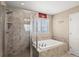 Bright bathroom featuring a shower, soaking tub, and window at 1382 Raindrop Way, Castle Rock, CO 80109