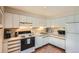 Efficient kitchen features white cabinets, appliances, and a traditional tile floor at 960 N Sherman St # 3F, Denver, CO 80203