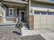 Home's entry featuring a covered porch with stone accents and a well-manicured yard at 13261 E 110Th Pl, Commerce City, CO 80022