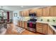 Bright kitchen with stainless steel appliances, wood cabinets, and a view of the adjacent breakfast nook at 2556 E 131St Pl, Thornton, CO 80241