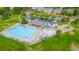 Aerial view of a fenced community pool, kiddie pool, playground, clubhouse, parking lot, and grassy lounge areas at 2556 E 131St Pl, Thornton, CO 80241