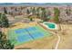 Aerial view showcases tennis courts, pool, and green spaces surrounded by trees at 5050 W 102Nd Ave, Westminster, CO 80031