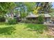 Lush backyard with a covered patio, deck, and mature trees providing ample shade at 5050 W 102Nd Ave, Westminster, CO 80031