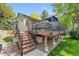 Wooden deck featuring an outdoor living area with stairs down to a stone path and green lawn at 5050 W 102Nd Ave, Westminster, CO 80031