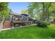 Elevated deck overlooking a sprawling green lawn, with steps leading down to a patio area at 5050 W 102Nd Ave, Westminster, CO 80031
