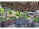 Covered patio with outdoor seating, a brick wall, and a view of the expansive green backyard at 5050 W 102Nd Ave, Westminster, CO 80031