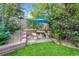 Private backyard patio with a stone bench, outdoor table, and lush landscaping at 5050 W 102Nd Ave, Westminster, CO 80031