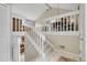 Open hallway with staircase featuring white railings and views of the living room and dining area at 5050 W 102Nd Ave, Westminster, CO 80031