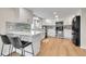 Open kitchen featuring breakfast bar, stainless appliances, gray backsplash and wood flooring at 5050 W 102Nd Ave, Westminster, CO 80031
