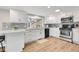 Bright open kitchen with modern appliances, white cabinets and gray tiled backsplash at 5050 W 102Nd Ave, Westminster, CO 80031