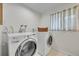 Modern laundry room with updated washer and dryer, window, and practical storage solutions at 5050 W 102Nd Ave, Westminster, CO 80031