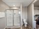 A clean bathroom featuring a glass shower, toilet, and linen storage space at 11650 Park South Ln, Parker, CO 80138