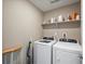 Functional laundry area with modern machines and a built-in storage shelf at 11650 Park South Ln, Parker, CO 80138