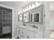 Bathroom featuring double sinks with marble countertops, vanity mirrors, and walk-in closet at 19334 E Prentice Pl, Centennial, CO 80015