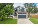 Charming two-story home with blue siding, stone accents, a well-manicured lawn, and an attached two-car garage at 19334 E Prentice Pl, Centennial, CO 80015