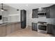 Modern kitchen with dark cabinets, stainless steel appliances, and a stylish marble countertop bar at 19334 E Prentice Pl, Centennial, CO 80015