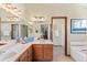 Main bathroom with double vanity and view into bedroom at 9436 Wickerdale Ct, Highlands Ranch, CO 80130