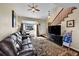 Spacious living room with hardwood floors, staircase, and large window overlooking the street at 7835 Canvasback Cir, Littleton, CO 80125