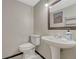 Cozy powder room featuring a pedestal sink and modern fixtures at 3614 W Radcliff Ave, Denver, CO 80236