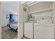 Practical laundry area with washer, dryer, and storage shelves at 3614 W Radcliff Ave, Denver, CO 80236