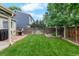 Well-kept backyard with green lawn, patio, grill, and fencing at 113 Rockaway Ave, Castle Rock, CO 80104