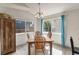 Sunlit dining area featuring a wood table and chairs, large windows with curtains, and tile flooring at 113 Rockaway Ave, Castle Rock, CO 80104