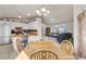 Bright dining area and kitchen with wood table, white cabinets, and view to living area with couches at 113 Rockaway Ave, Castle Rock, CO 80104
