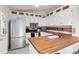 Well-lit kitchen featuring white cabinets, butcher block countertops, and stainless steel appliances at 113 Rockaway Ave, Castle Rock, CO 80104